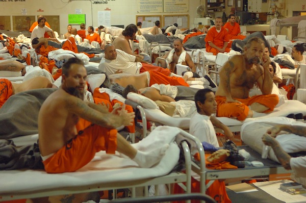 A gymnasium serves as an impromptu living area for hundreds of inmates at a California prison, leading to increased violent encounters.