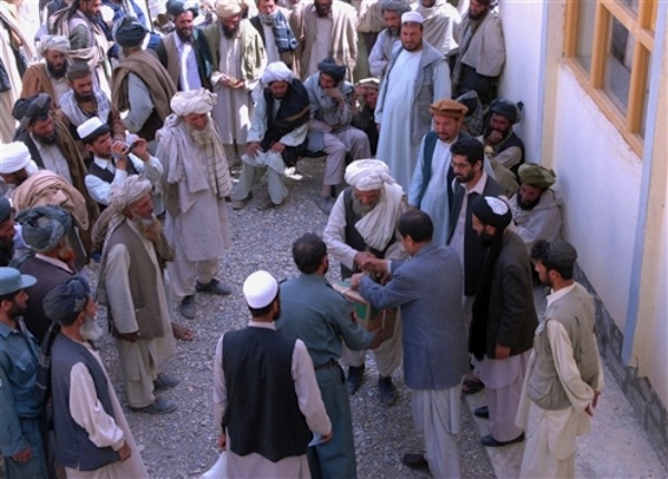 A Kuchi elder shakes hands and accepts cooking oil from Ali Khashe, deputy governor of Afghanistanâ€™s Wardak province, June 8, 2009. Sacks of beans, sugar, flour and rice brought in by U.S. soldiers were distributed by Afghan officials in an effort to ease tensions between the Kuchi and Hazara tribes. U.S. Army photo by Sgt. Rob Frazier