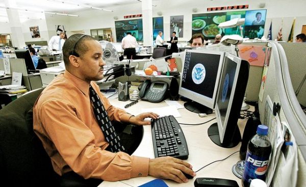 Unidentified personnel work at the National Targeting Center of the Customs and Border Protection at an undisclosed location in a Washington suburb in northern Virginia in this Dec. 1, 2006, file photo. The government has decided to continue to subject every American who travels abroad to a computerized risk assessment of whether he or she is a potential terrorist.