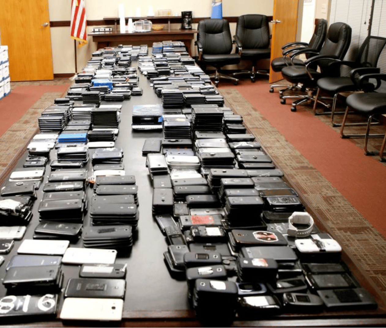 More than 1,600 cellphones that were taken from inmates in different Oklahoma prisons are displayed on a table at the Department of Corrections offices in Oklahoma City in 2018.